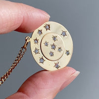 13 stone stars in circles within a solid 18k gold pendant