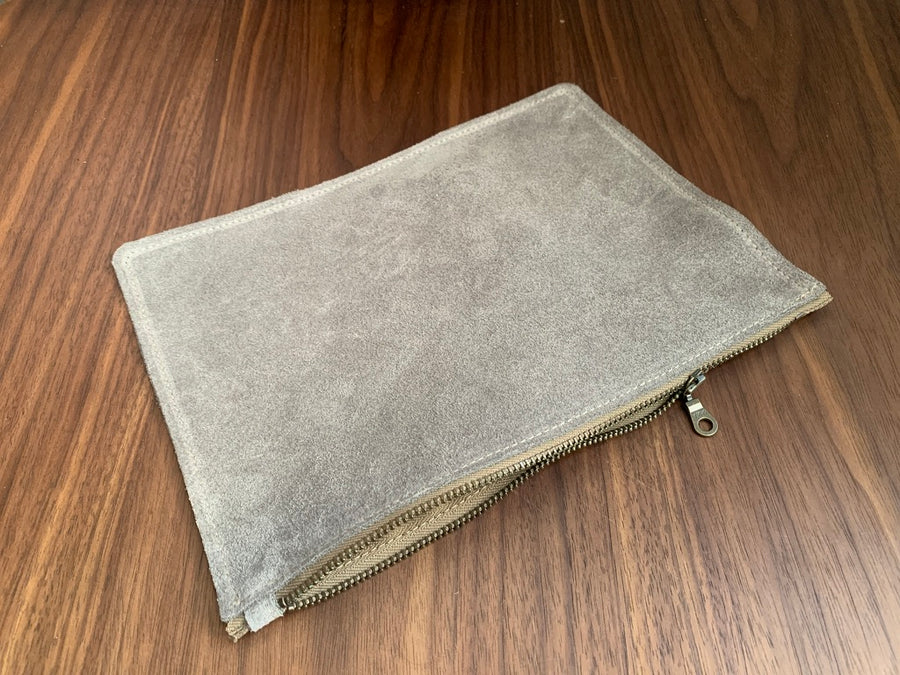 Simple leather zipper pouch to keep you organized.  Bovine suede.  Measures 10” x 7”  Metal zip with donut pull. Attach a wrist strap to zipper tab to make this into a clutch.