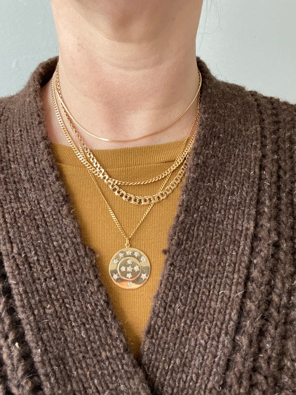 a woman wearing a collection of 18k gold vintage swedish necklaces